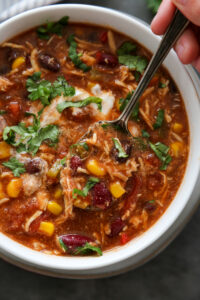 overview shot of chicken chili with spoon and cilantro