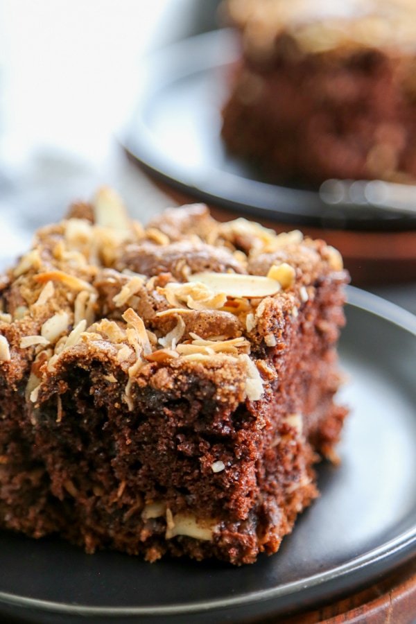 piece of chocolate almond coffee cake on black plate with fork