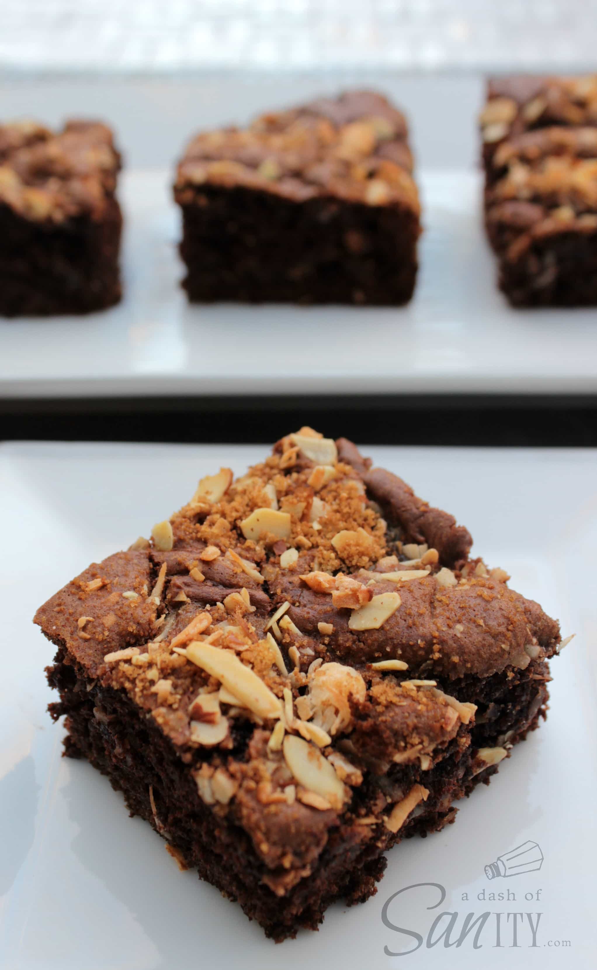 Chocolate Coconut Almond Coffee Cake square served on a plate, with 3 squares on serving tray in background