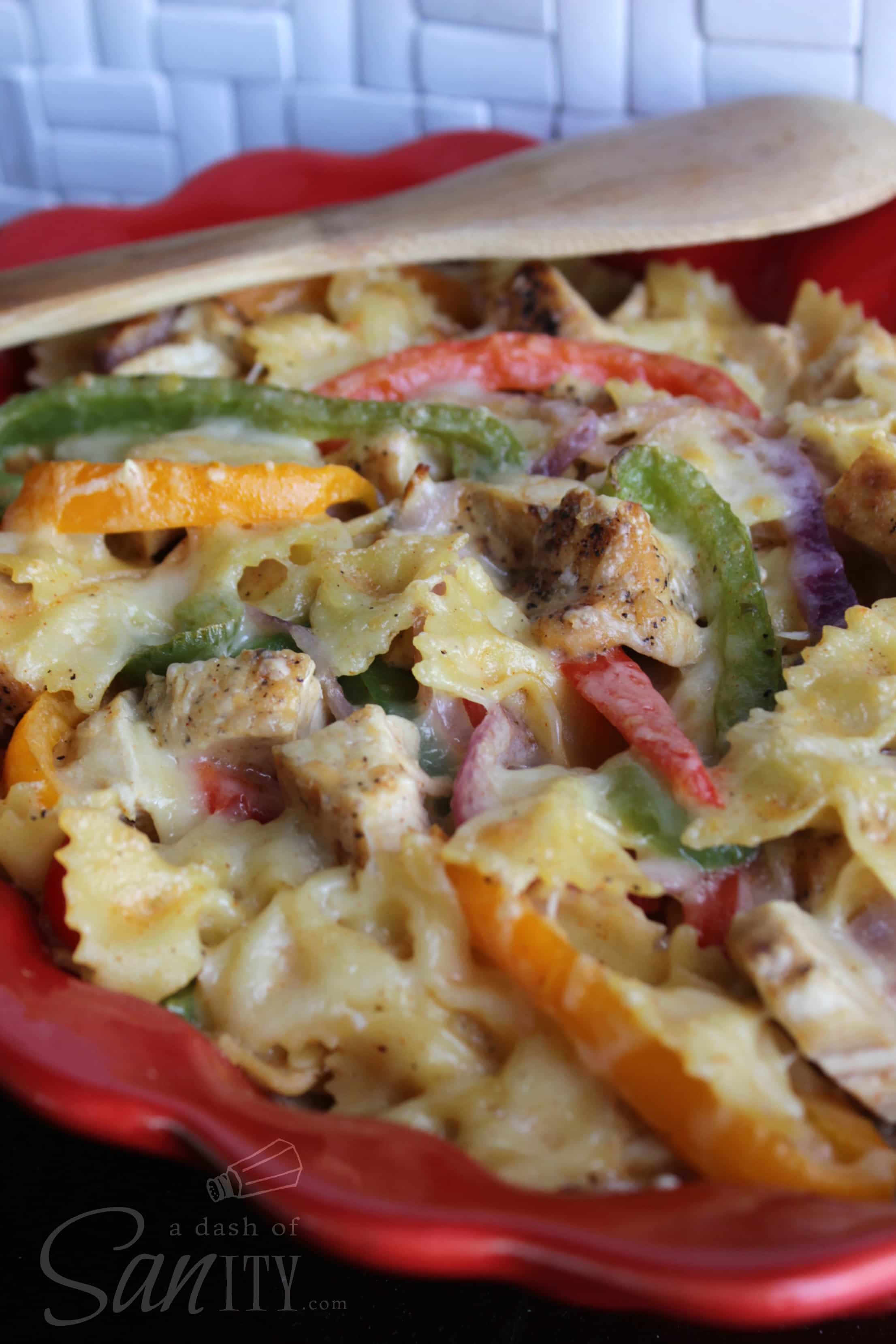 up close Cajun Chicken Pasta Bake with a wooden spoon