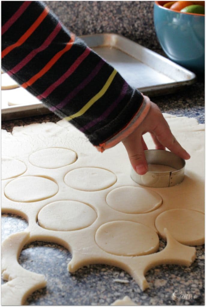 photo of cutting out tagalong cookie dough with round cookie cutter on counter