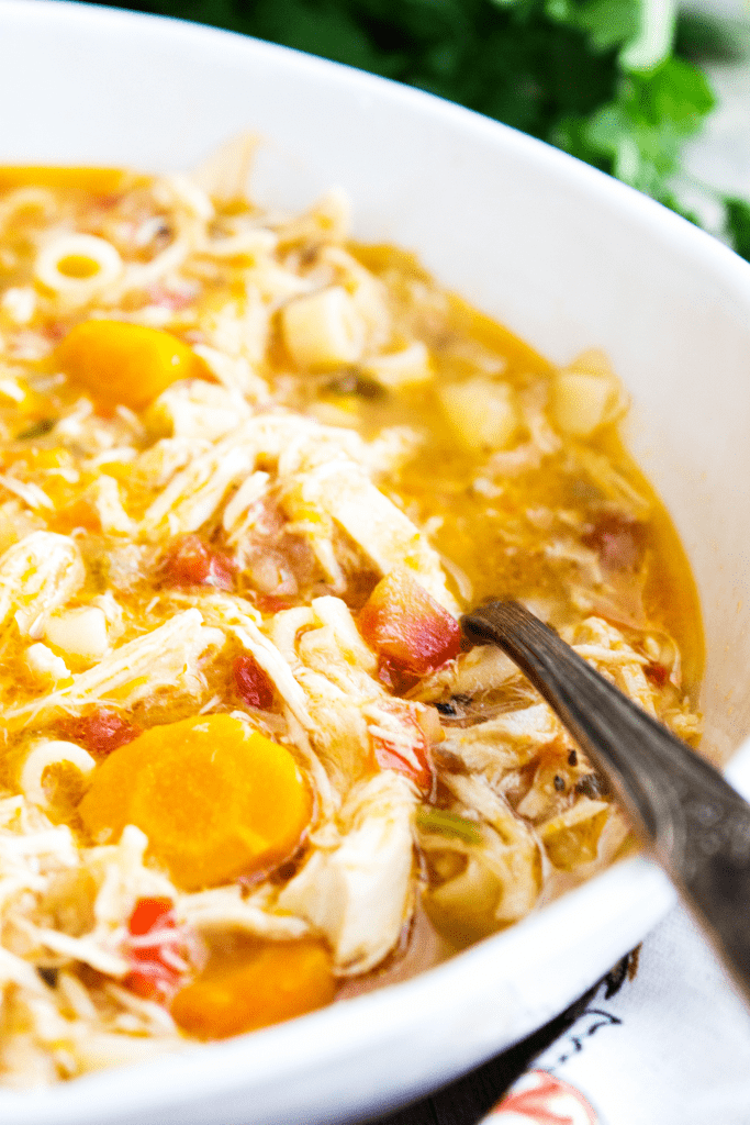 sicilian chicken soup in a white bowl with a spoon