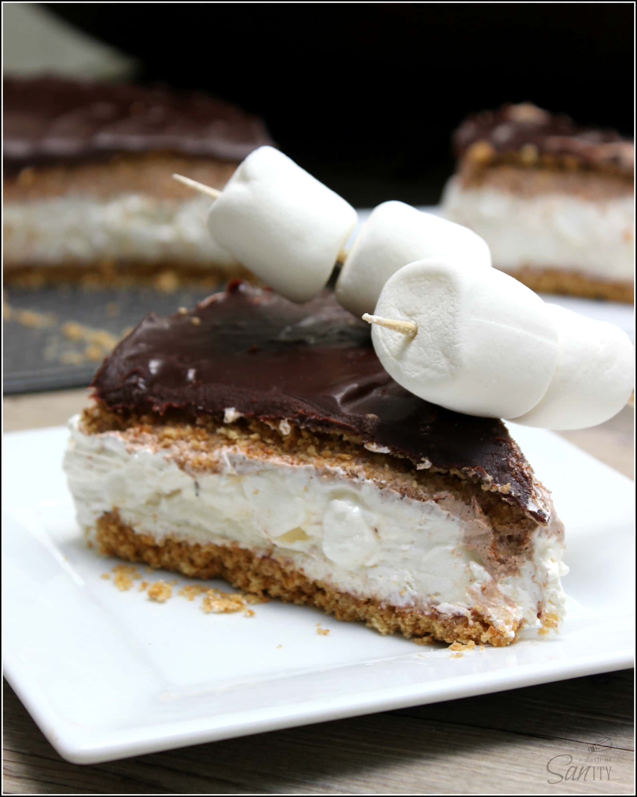 S'mores No Bake Cheesecake- inspired by the famous campfire treat. Made with marshmallow cream, graham cracker crust. & a rich chocolate ganache.