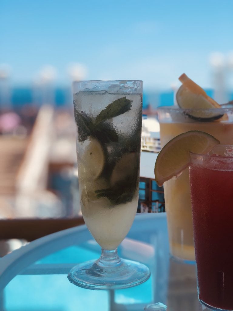 photo of virgin mojito and other drinks on a glass table on cruise ship deck