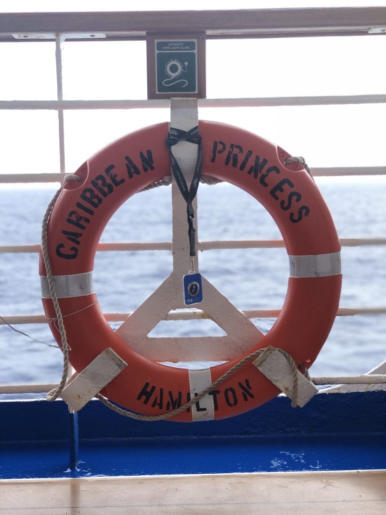 photo of a lifesaver with "caribbean princess hamilton" painted on it, hanging from railing on cruise ship