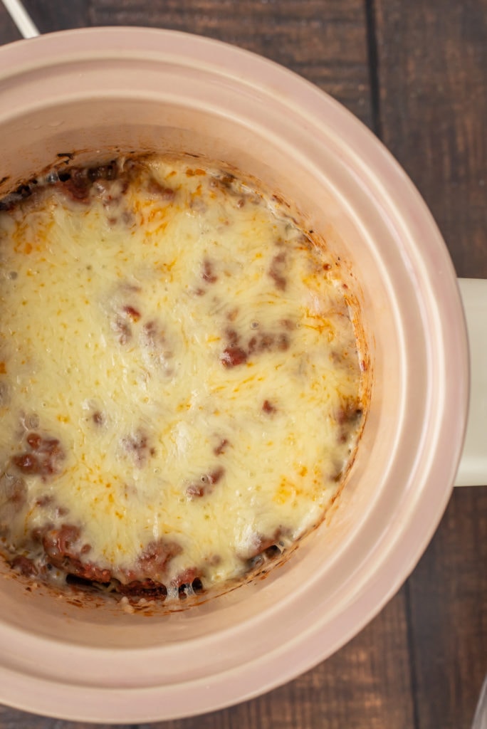 overhead photo of the lasagna in the slow cooker topped with melted cheese