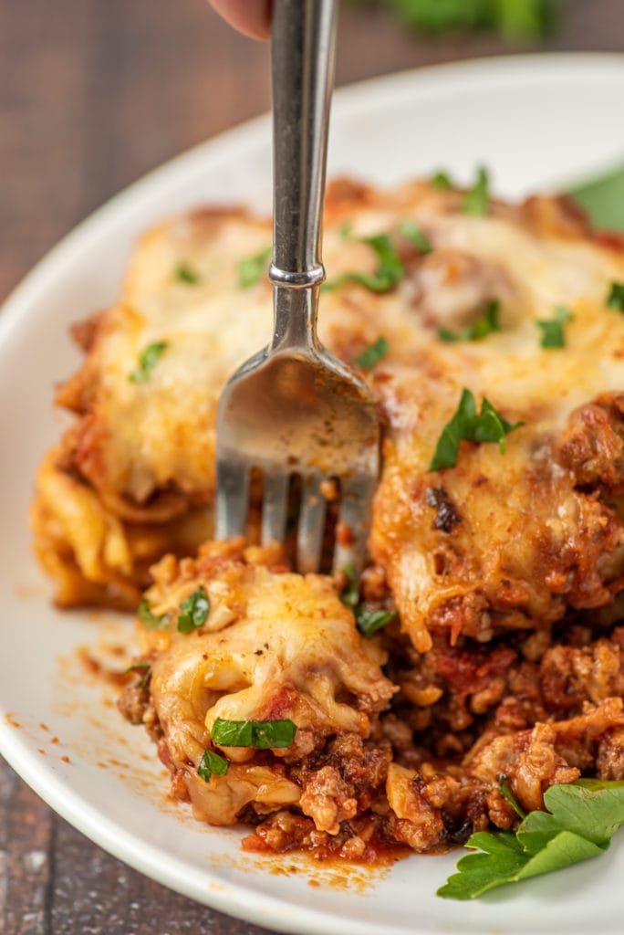 close-up photo of a fork cutting off a bite of lasagna