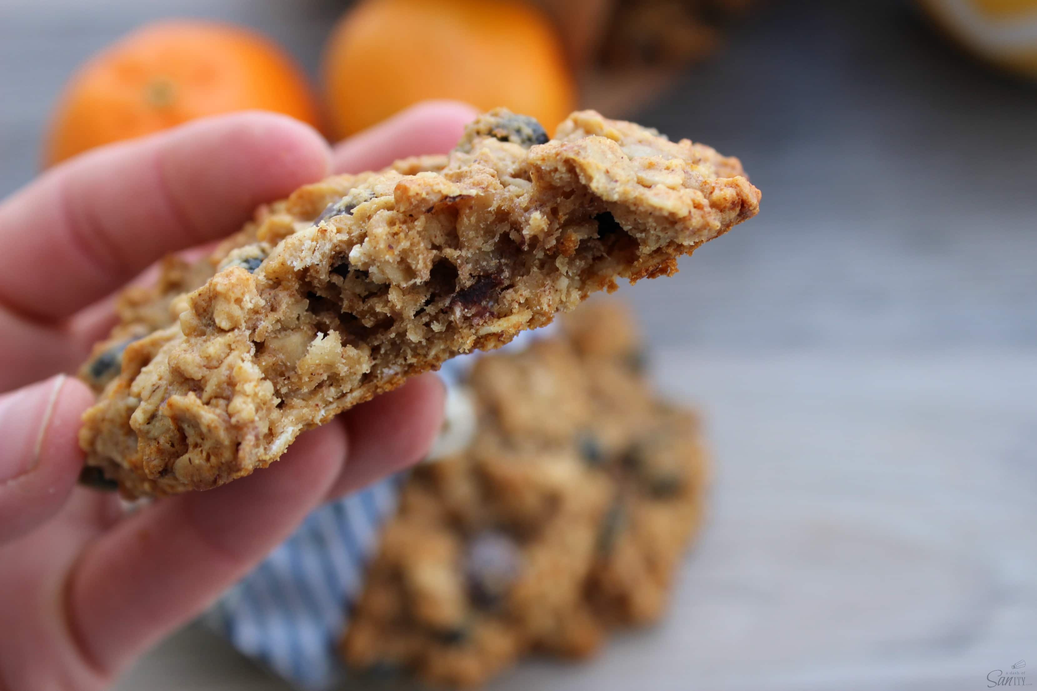These Oatmeal Breakfast Cookies are a tasty protein filled way to the start off your day. They make a great snack to power through the afternoon. a hand holding a cookie with a bite taken out of it