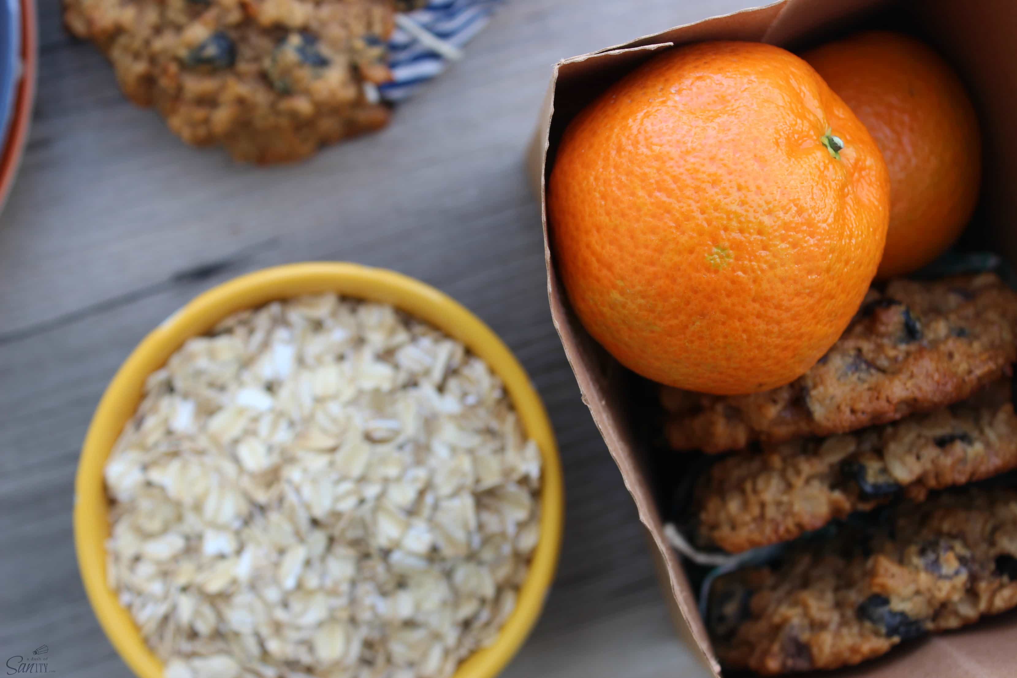 These Oatmeal Breakfast Cookies are a tasty protein filled way to the start off your day. They make a great snack to power through the afternoon. a bowl of oats with an orange