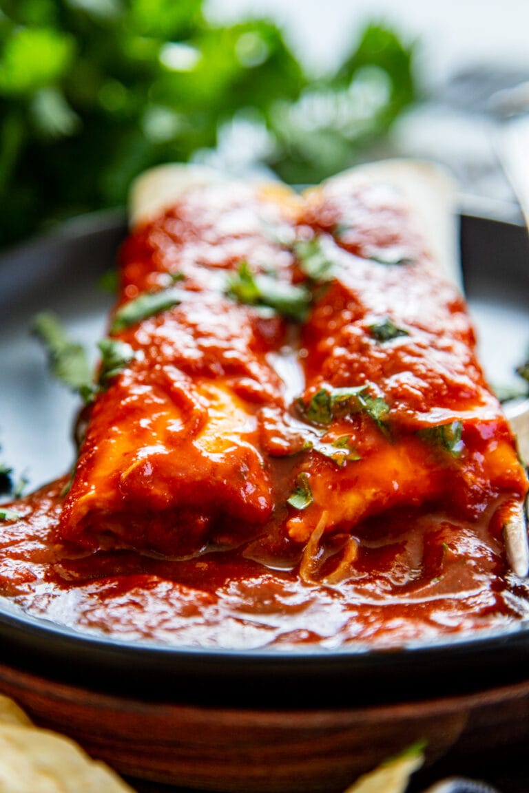 black plate with 2 cheese enchiladas with red sauce