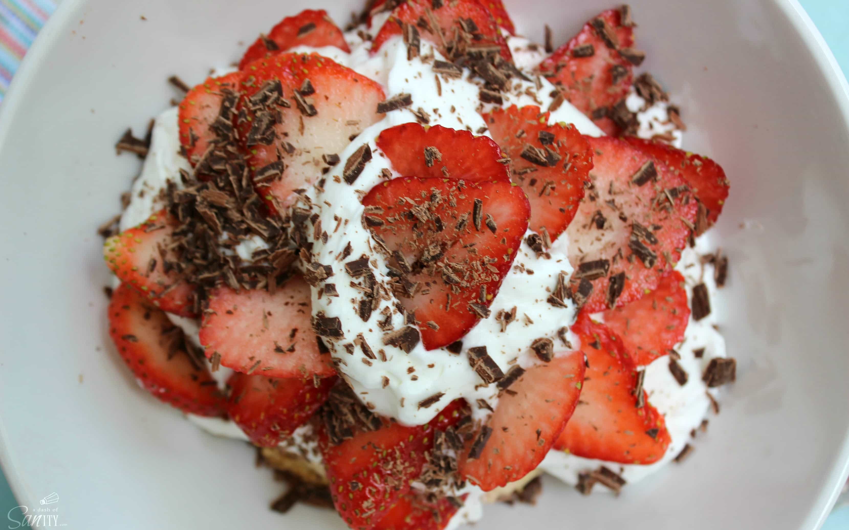 Strawberry & Rhubarb Chocolate Chip Shortcakes is a homemade rhubarb & chocolate chip biscuit, with fresh strawberries, whipped cream, & chocolate shavings.