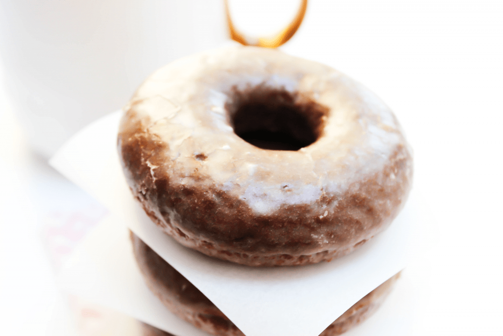 Devil's Food Donuts in a stack separated by parchment paper squares