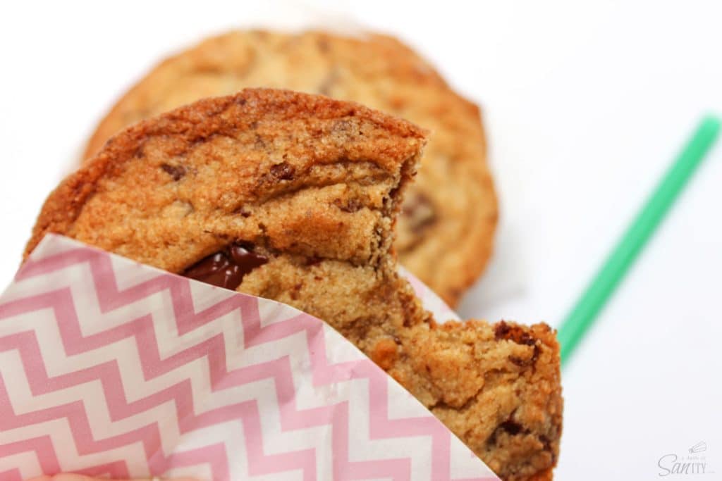 Copycat Starbucks Chocolate Chip Cookie wrapped in parchemnt up close with bite taken out