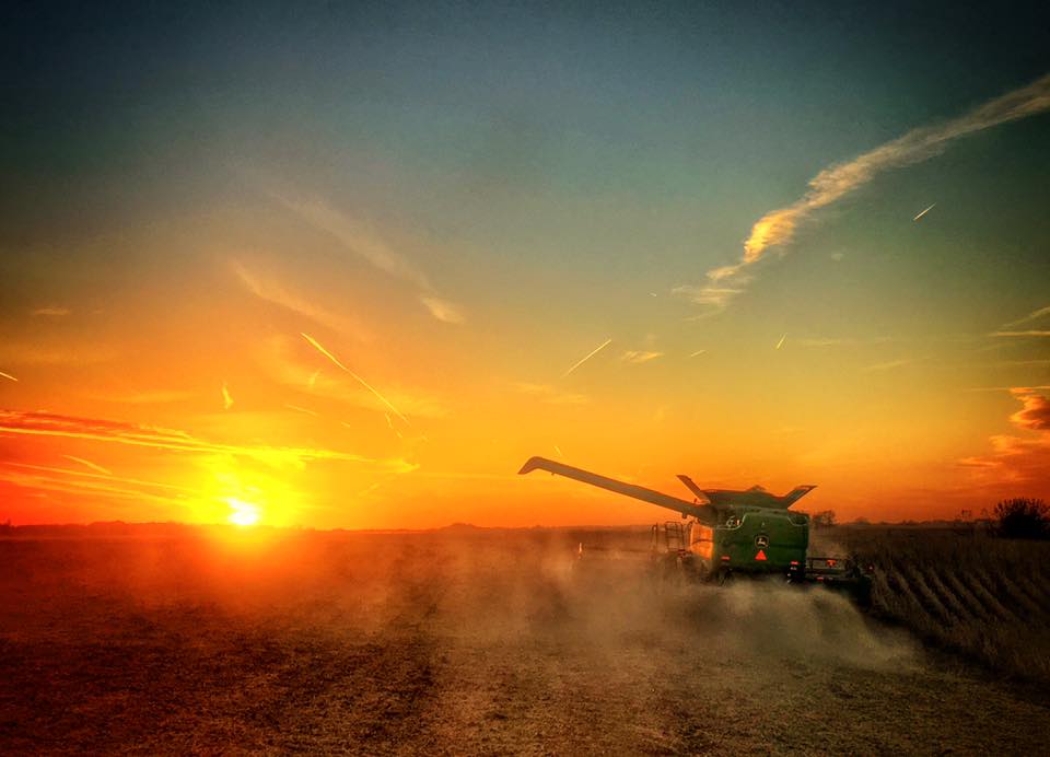 sunrise on farm with tractor spraying a field