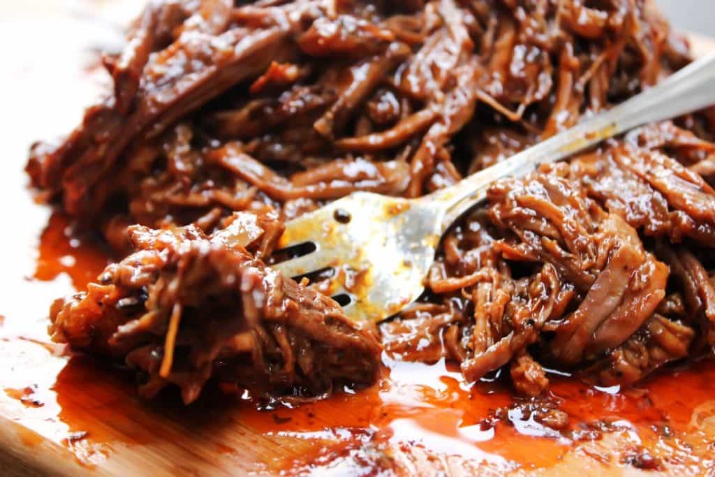 photo of Easy Barbecue Beef Brisket on cutting board with fork 