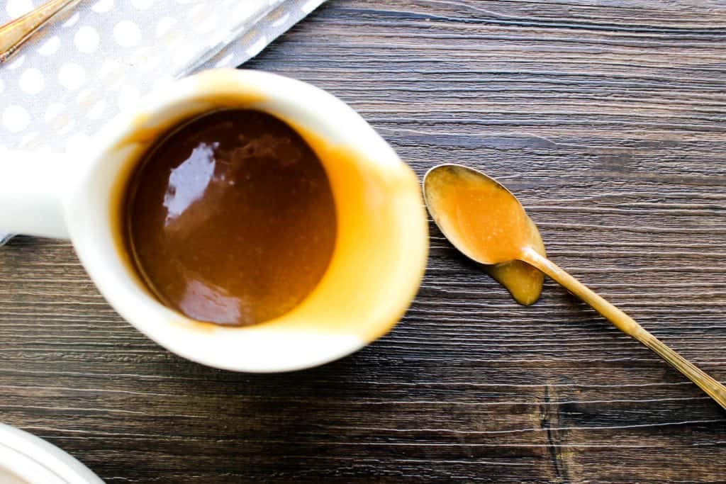 Peanut Butter Caramel Sauce in a gravy dish with a spoon 