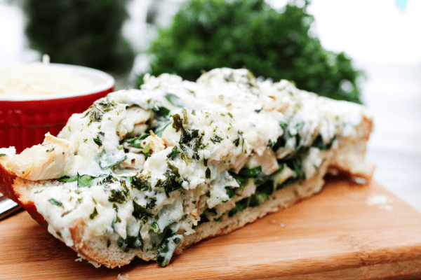 This Stuffed Chicken Alfredo Bread is an easy meal or tasty game day appetizer, filled with chicken, cheese, spinach, and topped with Alfredo sauce.