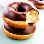 two cake donuts stacked one with a bite out of it