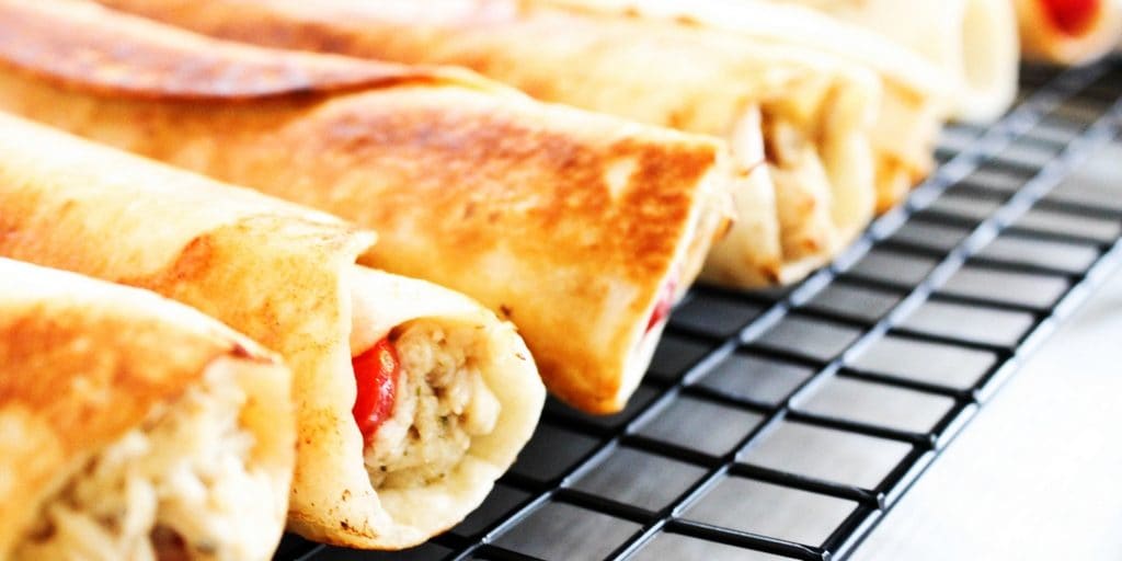 Slow Cooker Greek Chicken Taquitos is a twist on classic chicken taquitos. Made with fresh tomatoes, feta, and Greek dressing, this is so easy & delicious. 
