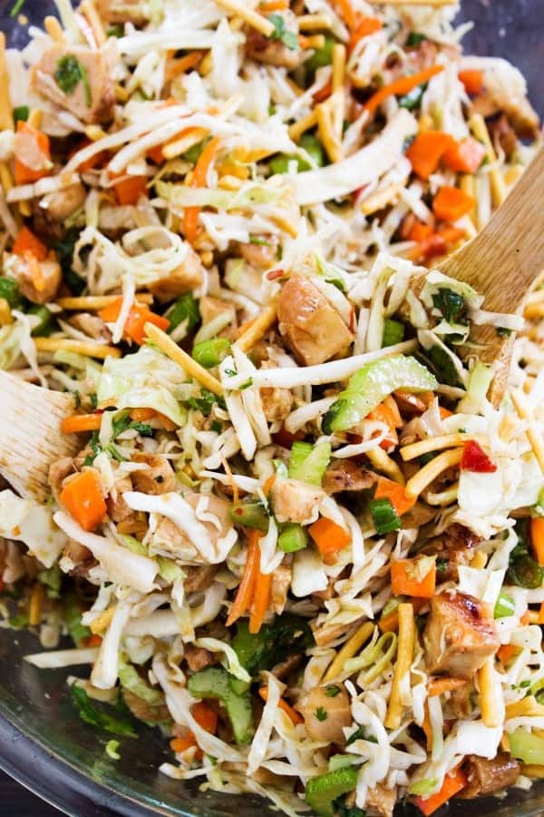 Chopped Asian Salad in a dark bowl with wooden spoons