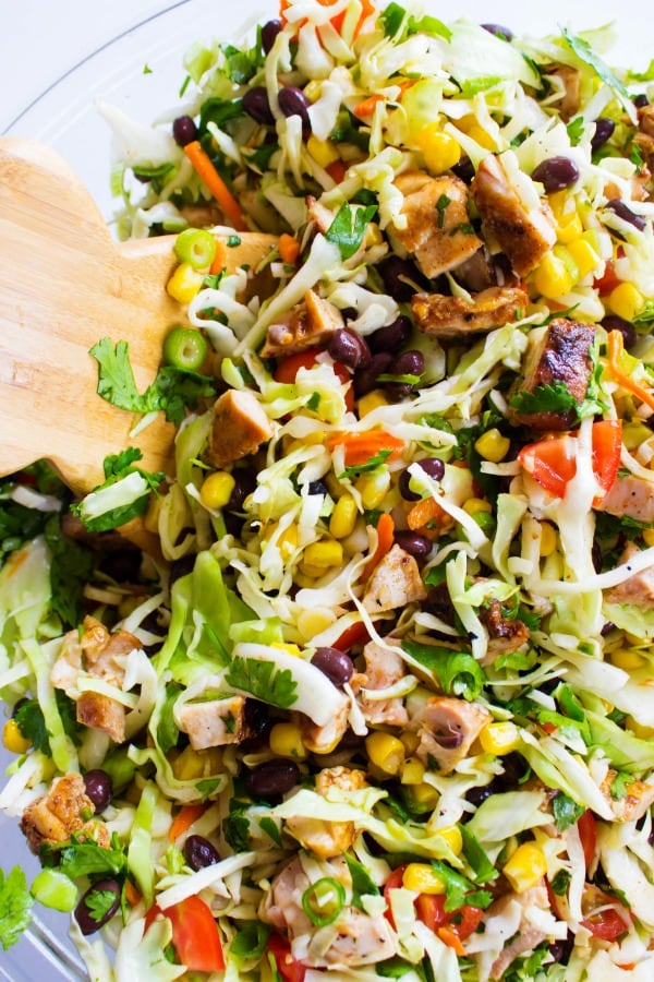 Chopped Southwestern Salad in a glass bowl with wooden salad tongs