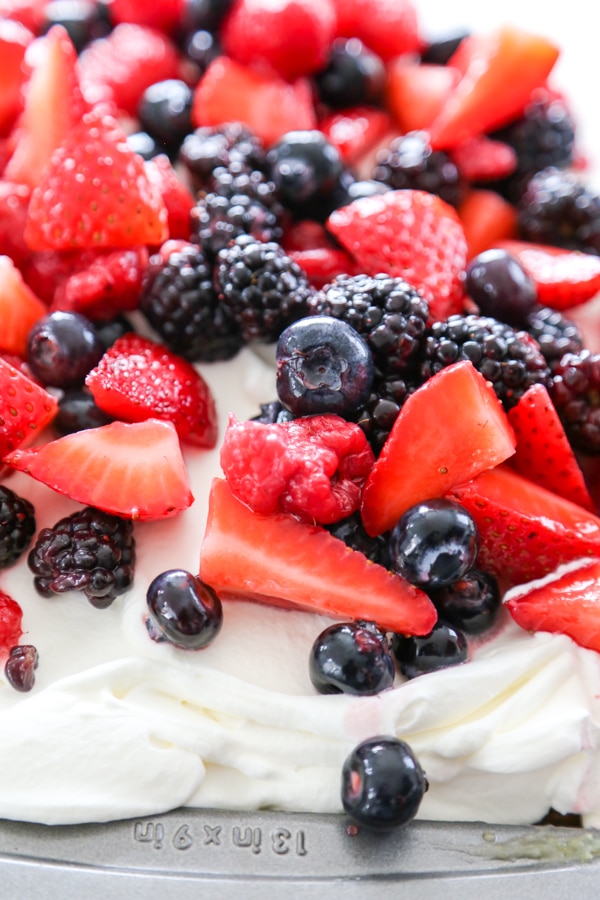 a poke cake topped with fresh berries.