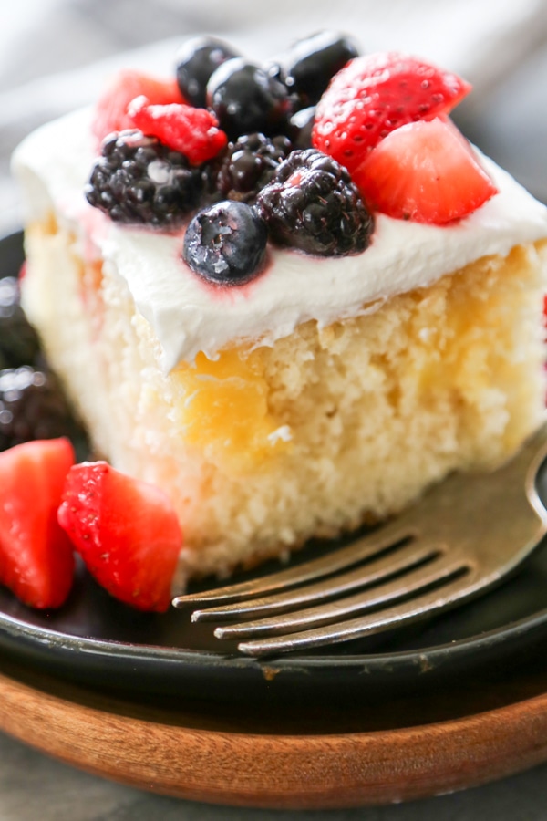 a slice of lemon curd poke cake on a plate.