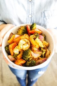 white bowl of cajun shrimp with someone holding it