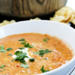 chicken chili dip in white bowl with chips