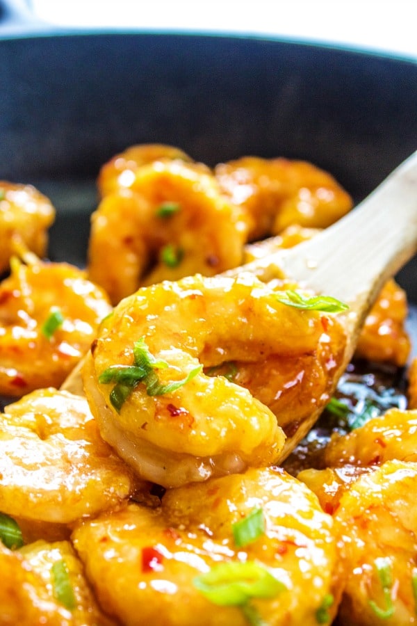 Firecracker Shrimp in a cast iron skillet with a wooden spoon