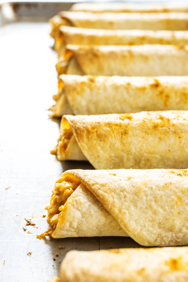 BAKED TACO RANCH TAQUITOS - Filled with a cheesy taco ranch chicken and then baked to perfection, they are perfect for any game day or holiday get together.