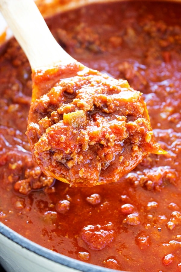 photo of a pot of chili with a wooden spoon