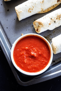 CHICKEN PARMESAN TAQUITOS - Filled with chicken, 3 cheeses and Italian seasoning, dunk these taquitos in a marinara sauce and you have an easier & simpler twist on an Italian classic.