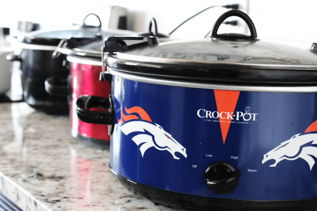 four slow cookers on a kitchen counter