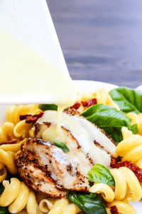 lemon butter sauce pouring over grilled chicken