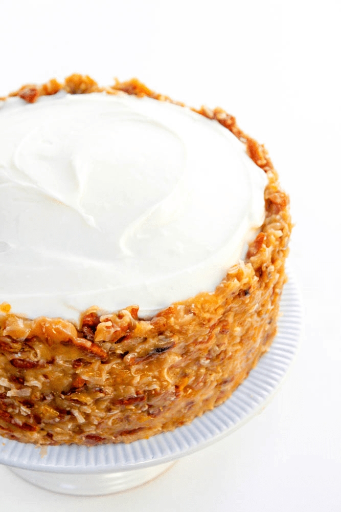 frosted German Chocolate Carrot Cake on a white cake stand