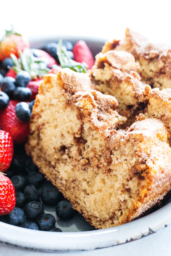 photo of slices of cinnamon sugar bread on a plate with fresh strawberries and blueberries