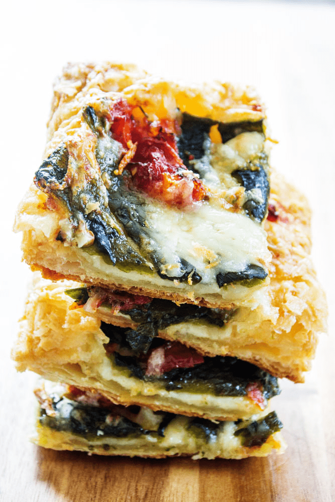 Roasted Chile Cheese Tart sliced into squares stacked up close