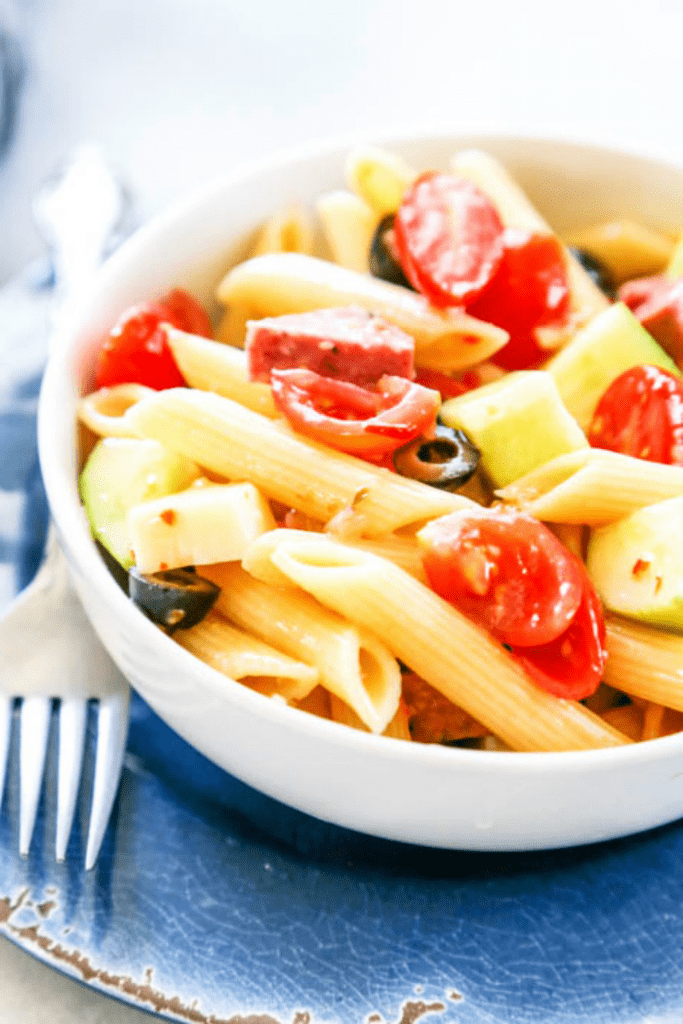 Easy Pasta Salad with Italian dressing, penne pasta, tomatoes, cucumbers, cheese, olives and salami