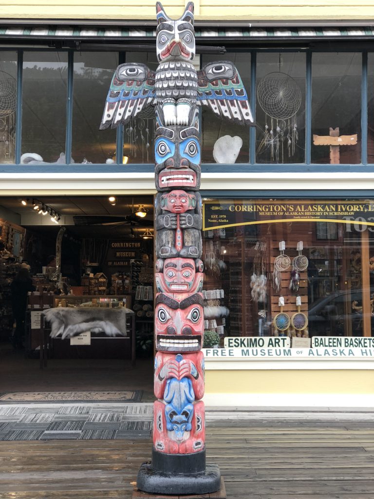 front of a shop with a carved eskimo pole