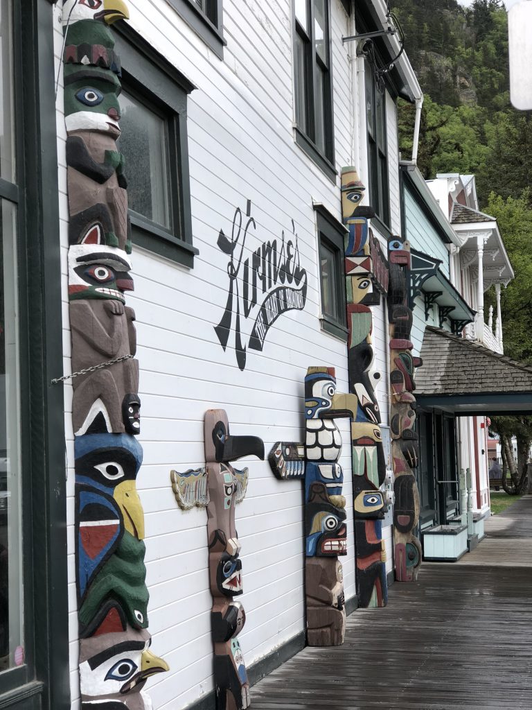 outside of a shop with wooden animal carvings on side of building