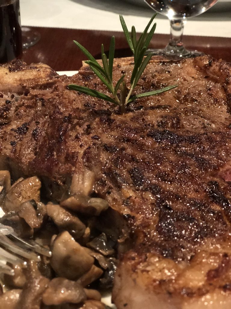 up close image of steak with mushrooms on side