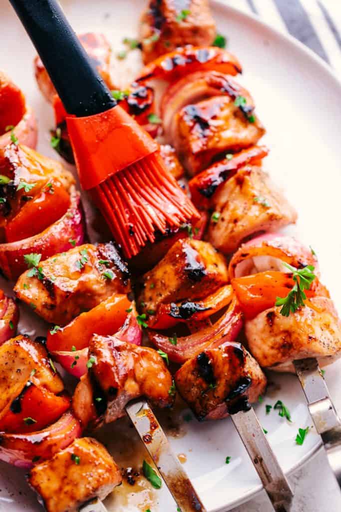 brushing pork skewers with marinade