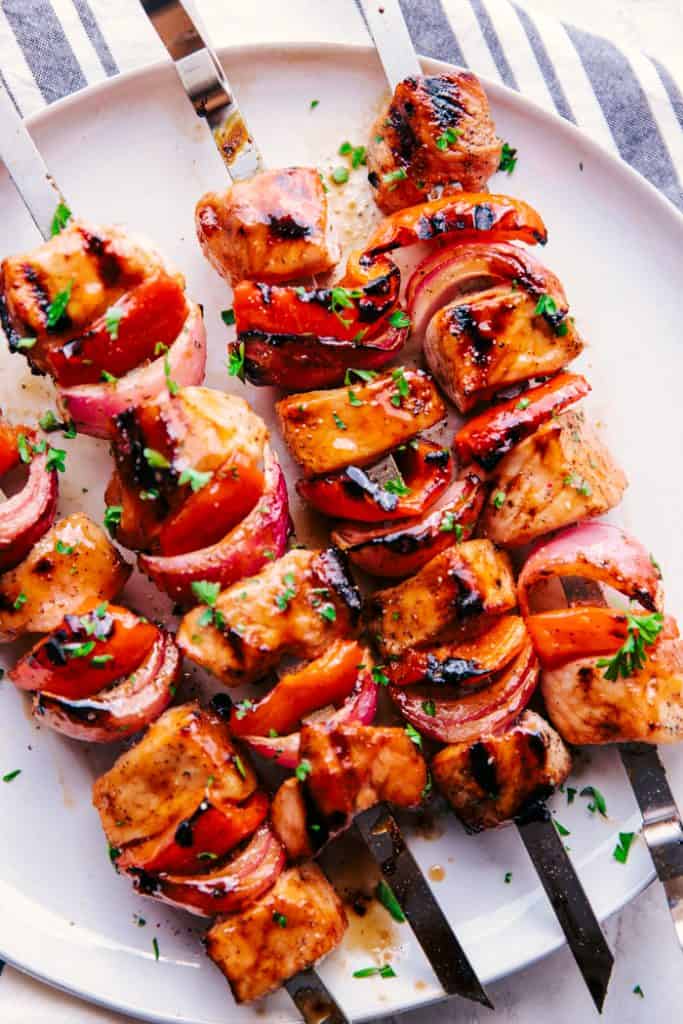 grilled pork skewers on a white plate