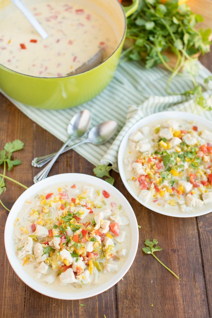 Mexican Corn Chowder in a pot next to two white bowls of chowder