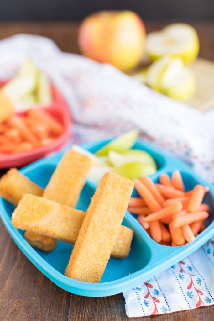 grilled cheese sticks on a blue kid's plate with baby carrots and apple slices