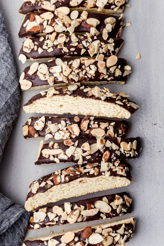 overhead photo of sliced biscotti dipped in chocolate and topped with almonds