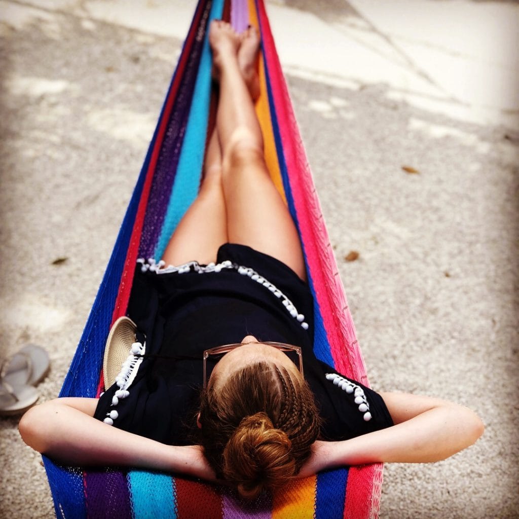 photo of teenage girl in a hammock on the beach