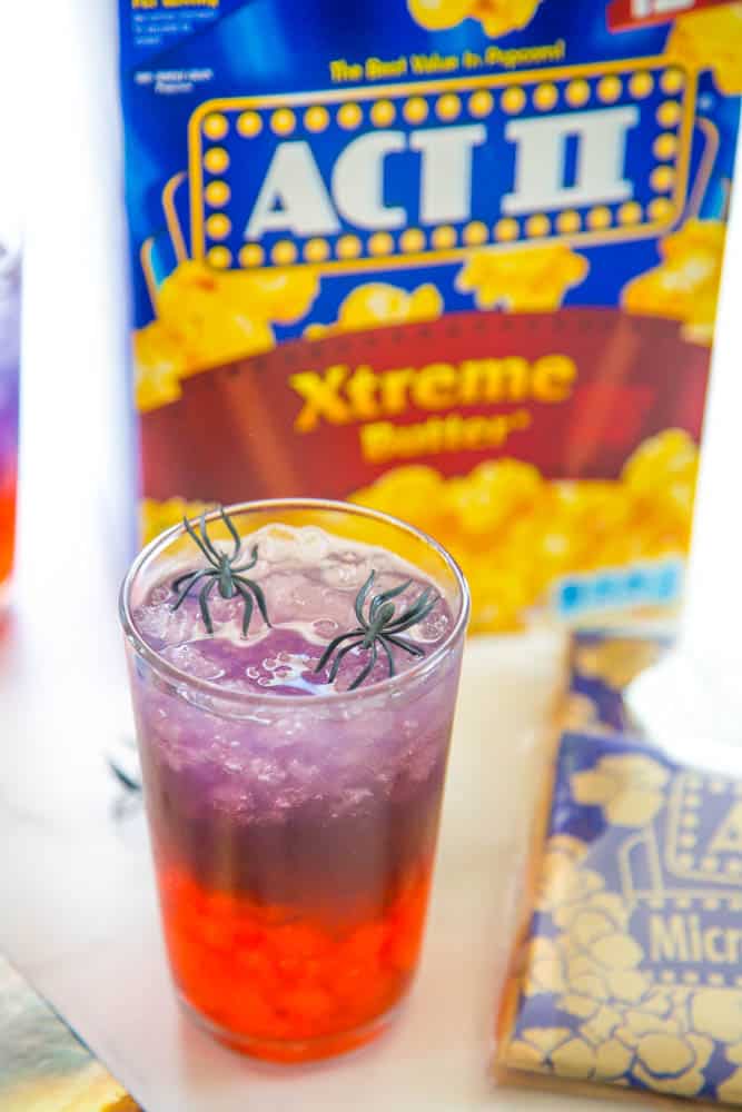 photo of glass of punch with popcorn box in the background