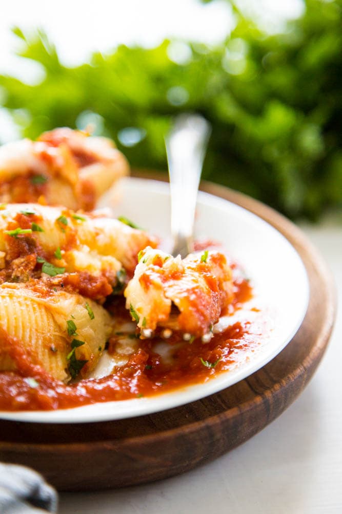 photo of stuffed shells and sauce on a plate with a fork.